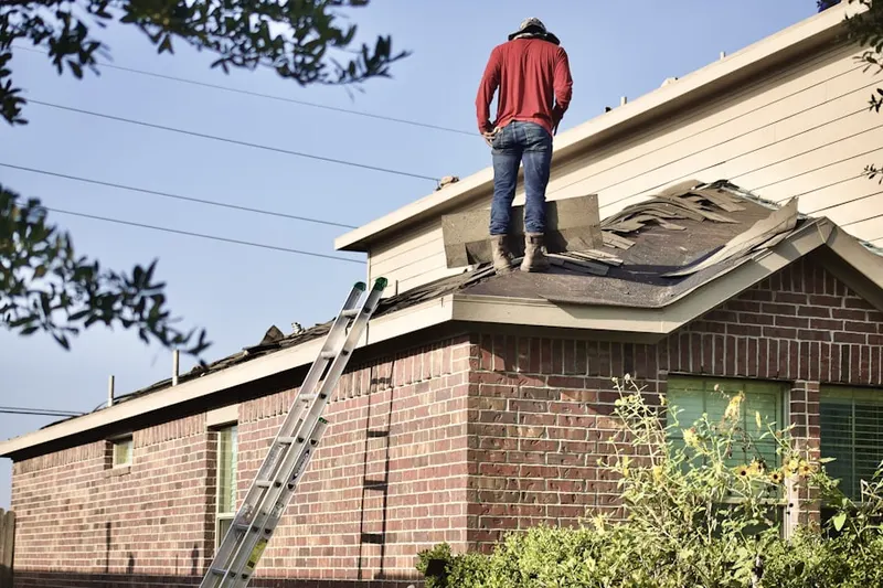 Professional roofer working on a residential roof in Wainscott
